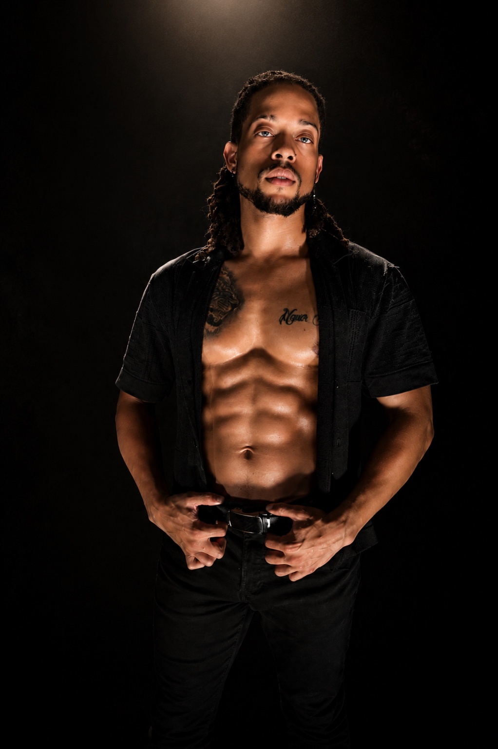 Hardbodies Live dancer in an open black shirt against a dark backdrop