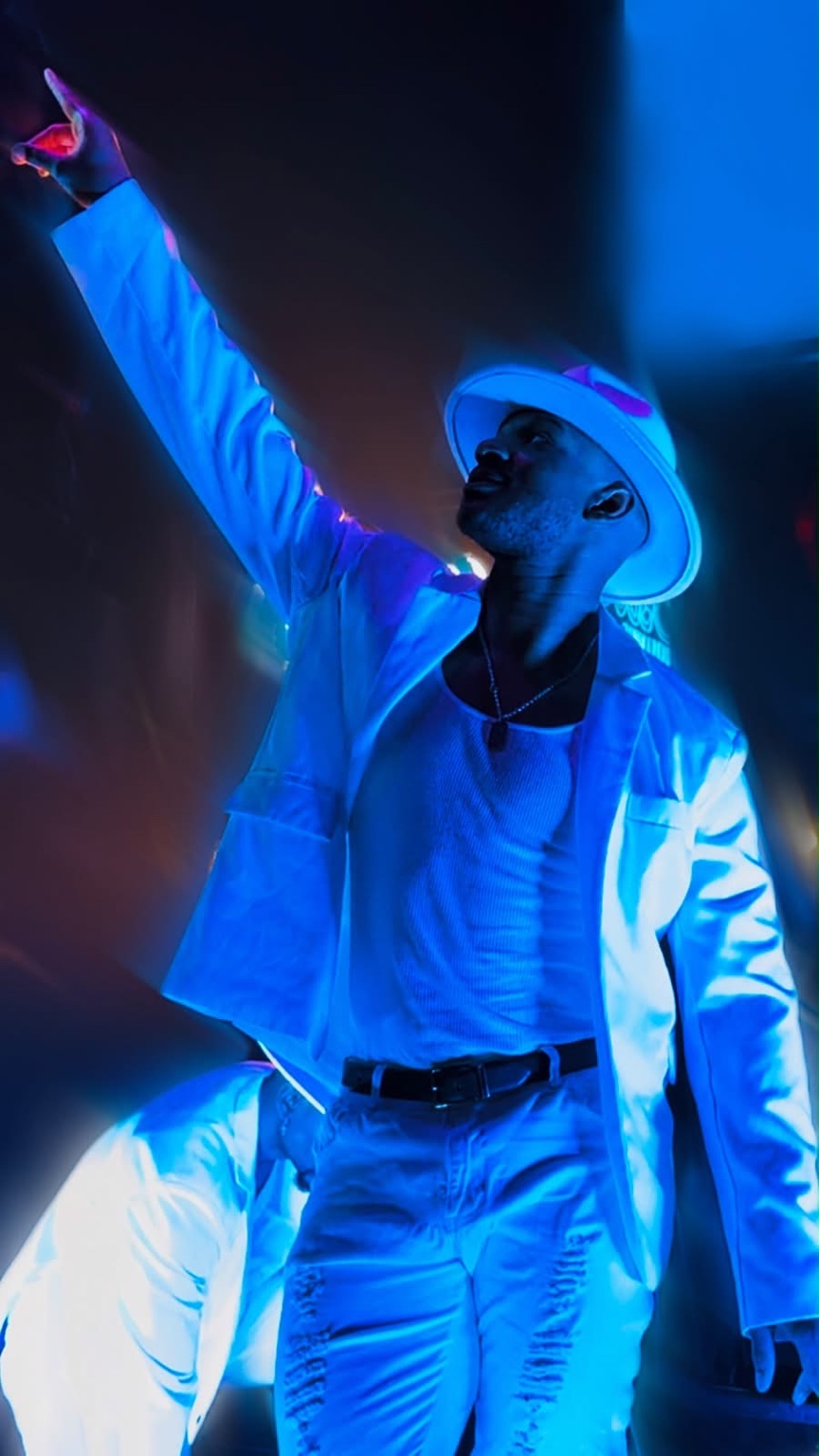 Hardbodies Live performer in a white suit and hat during a choreographed performance
