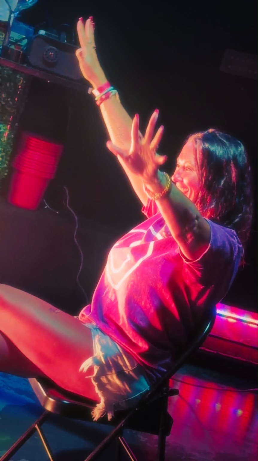 Excited guest cheering and reaching toward the stage at a Hardbodies Live show